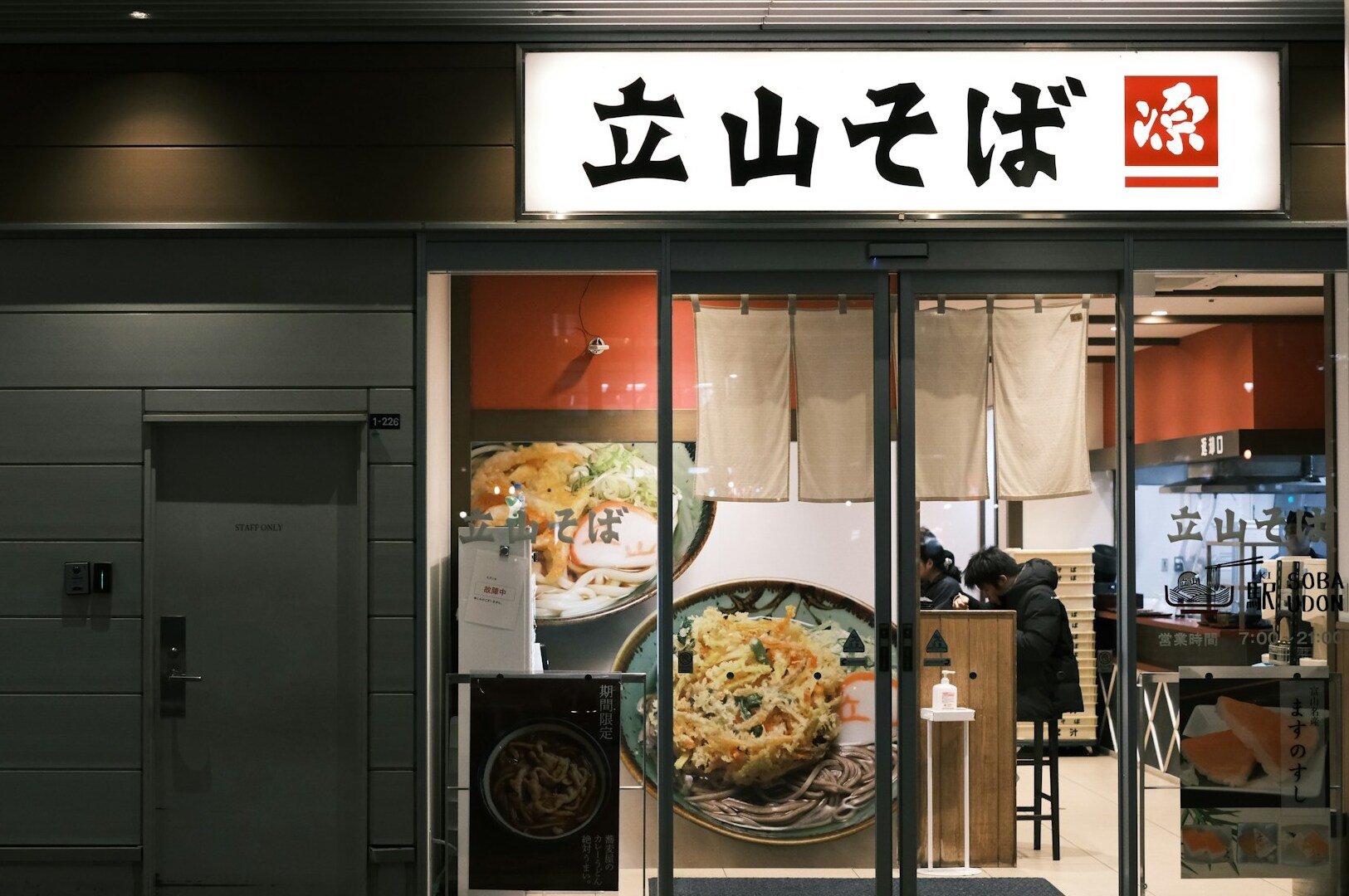 The image showcases the interior of an upscale Japanese restaurant featuring traditional design elements, with elegant wooden furnishings and soft lighting that create a warm atmosphere. Patrons can enjoy a variety of Japanese cuisine, including fresh sashimi and premium wagyu dishes, in this inviting setting reminiscent of the best Japanese buffets in Singapore.