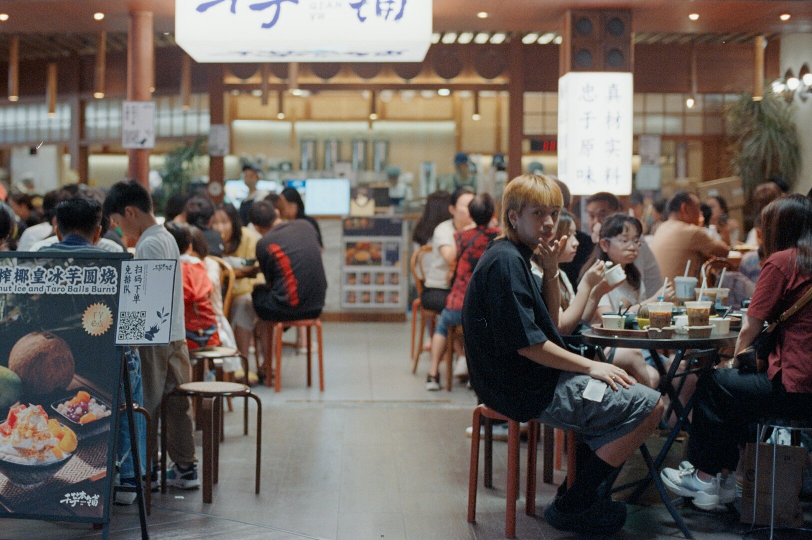 A group of people is enjoying a vibrant Japanese hotpot buffet, surrounded by an array of fresh ingredients including premium wagyu beef, fresh sashimi, and colorful vegetables. The atmosphere is lively as diners savor traditional Japanese dishes and engage in the communal experience of cooking at the table.