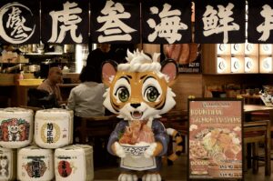 A tiger statue holding a bowl of Japanese cuisine in front of Tora-San, highlighting the dining experience in Singapore.