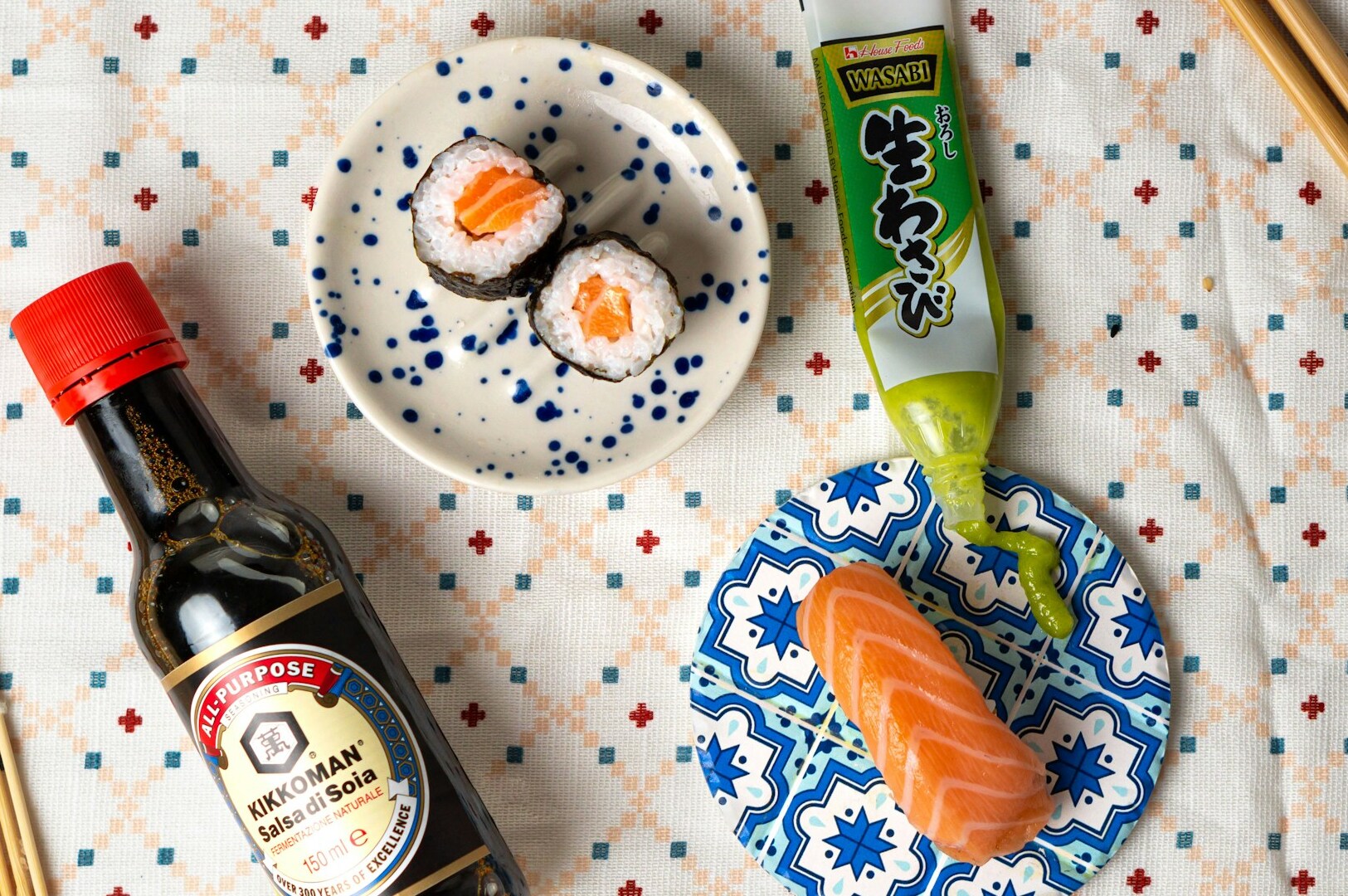 A plate featuring assorted sushi, a sauce bottle, wasabi, and chopsticks, the essence of Japanese dining culture.
