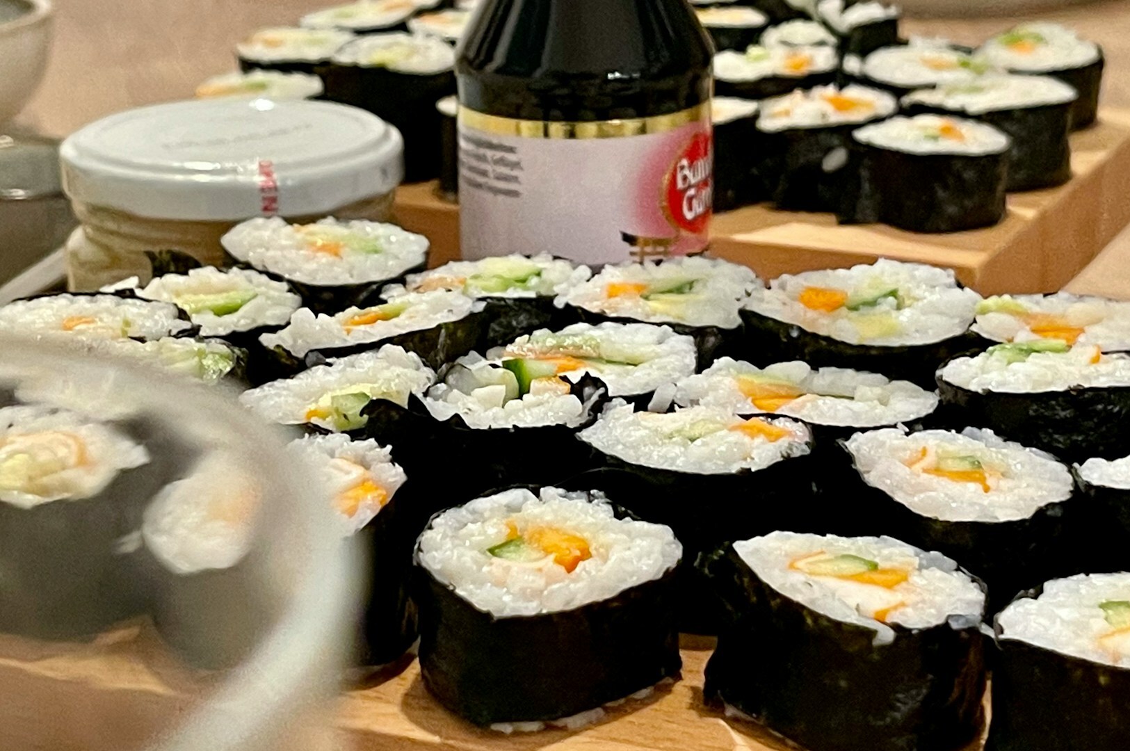 An array of sushi rolls arranged on a wooden cutting board, various sushi buffet selections in Singapore.