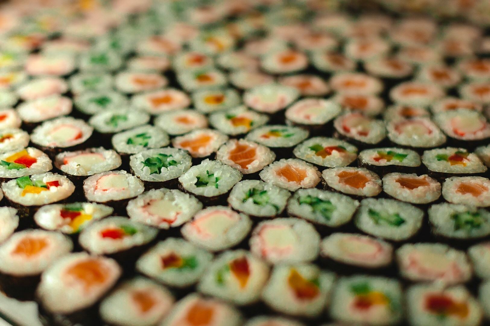 A beautifully arranged plate of sushi rolls from Hokkaido Sushi Restaurant, and various types and garnishes.