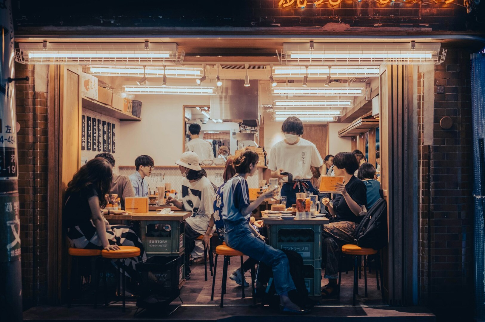 Guests savoring Japanese cuisine at a bustling restaurant in Singapore during the evening.