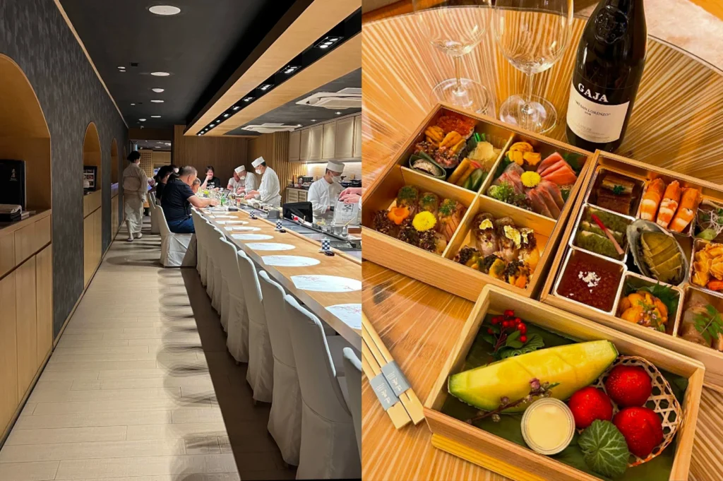 This image presents a contrast between a professional dining room and a luxury takeaway experience. The left half shows a long, bright sushi counter lined with white cloth-covered chairs where diners watch several chefs in white hats and masks prepare meals. The right half displays a high-end, multi-tiered wooden bento box set on a sun-drenched table, accompanied by a bottle of Gaja wine. The boxes are meticulously packed with an array of premium delicacies, including sliced sashimi, sea urchin (uni), abalone, and grilled wagyu, alongside a dedicated dessert box featuring fresh strawberries and a slice of melon.