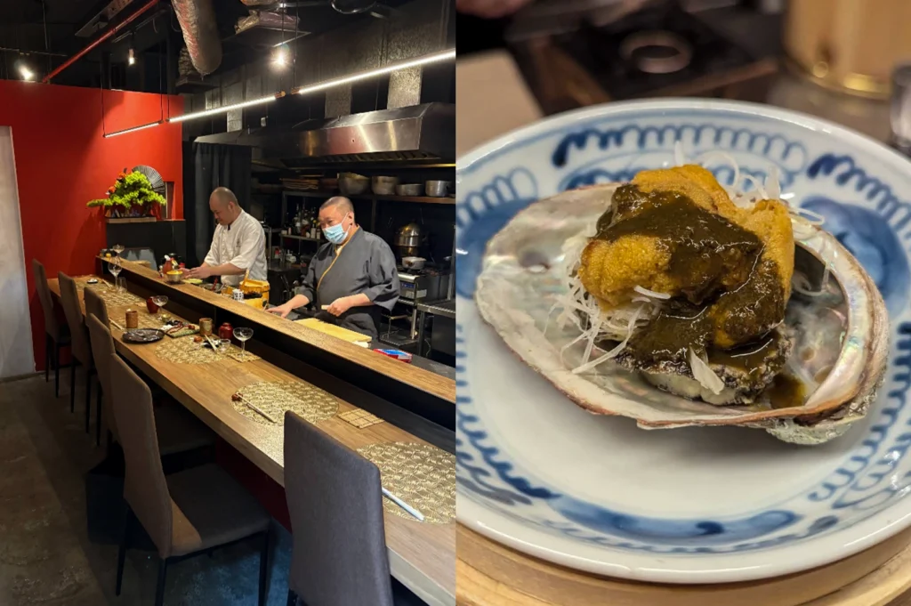 A split-screen image showing a moody, industrial-style sushi bar and an abalone specialty. The left side displays a long wooden bar with gold-patterned placemats, set against a bold red wall and an open kitchen where two chefs are prepping ingredients. The right side features a close-up of a blue-and-white patterned plate holding a whole abalone shell, which contains sliced abalone meat topped with a mound of creamy sea urchin and a dark, savory liver-based sauce.