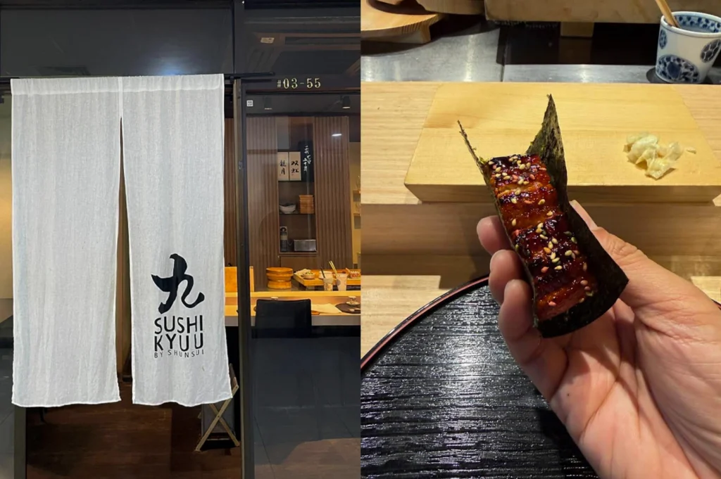 This composition highlights both the minimalist branding and a signature dish of "Sushi Kyuu by Shunsui." The left side shows a clean, white noren curtain hanging at a glass-paned entrance, featuring the restaurant's logo in black ink, which provides a glimpse into the warm, wooden interior. The right side is a close-up, first-person perspective of a hand holding a piece of unagi (grilled eel) sushi wrapped in a crisp sheet of nori seaweed. The eel is glazed in a dark, glossy sauce and sprinkled with white and yellow sesame seeds, held over a black textured lacquer tray with a wooden prep block in the background.