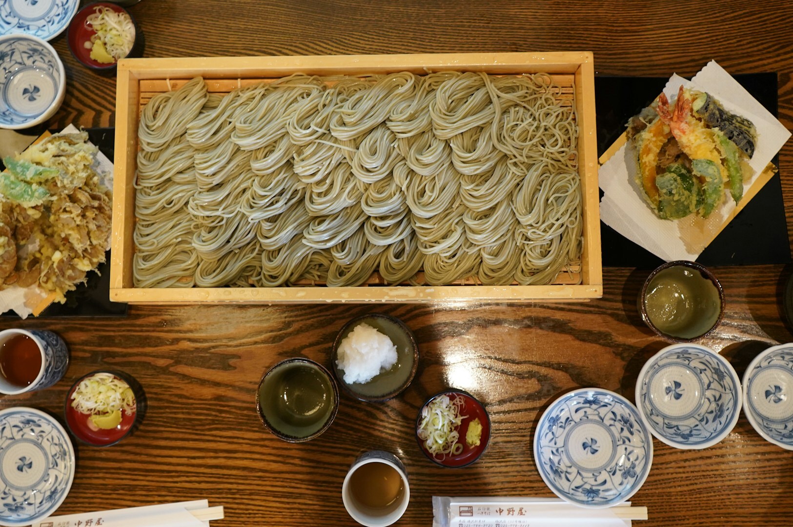 A beautifully arranged table featuring bowls of noodles and assorted dishes, highlighting the ambiance of a Japanese buffet.