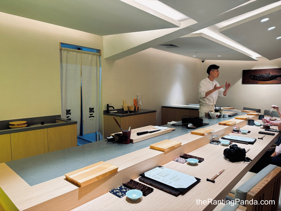 A man in front of Sushi Muni, a sushi bar emphasizing ingredient purity and quality.