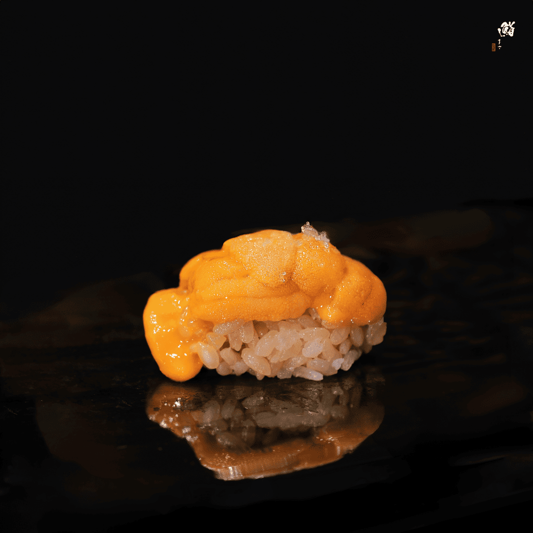 A single sushi piece displayed on a black background, showcasing the elegance of a premium omakase offering.