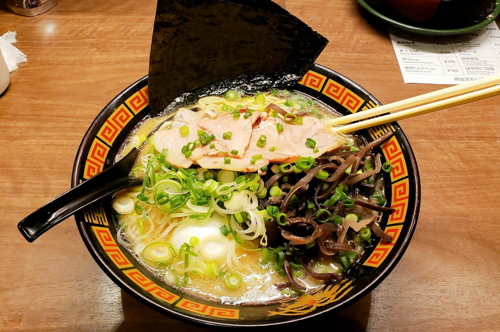 A bowl of ramen with chopsticks, featured at Omote Thomson Plaza, a fast-casual Japanese eatery.