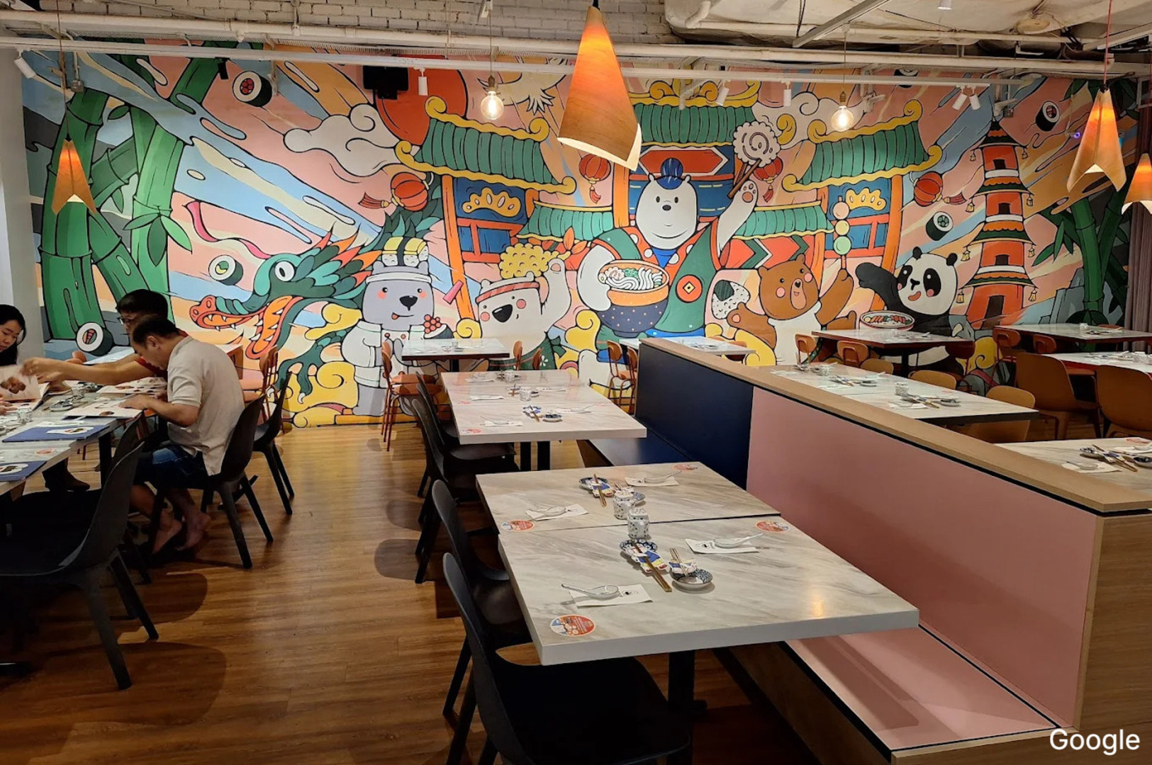 Interior of Omote Thomson Plaza restaurant showcasing lively murals on the walls, creating a vibrant atmosphere.