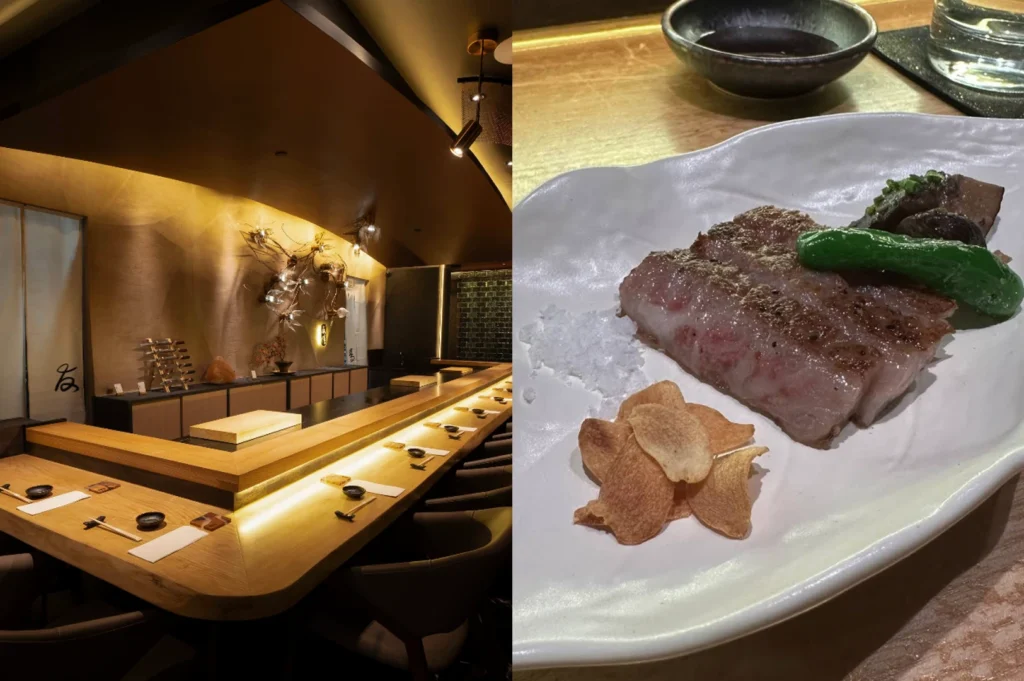 This split-screen image highlights the architectural beauty and the culinary richness of an omakase experience. The left side provides a wide view of an empty, L-shaped wooden dining counter under dramatic, warm spotlighting; the room features dark ceilings, minimalist decor, and a golden-textured accent wall. The right side is a top-down close-up of a main course served on a matte white irregular plate, featuring three thick, perfectly seared slices of wagyu beef. The beef is accompanied by a pile of golden garlic chips, a dollop of flaky sea salt, a charred green shishito pepper, and a dark mushroom, presenting a rich contrast of colors and textures.