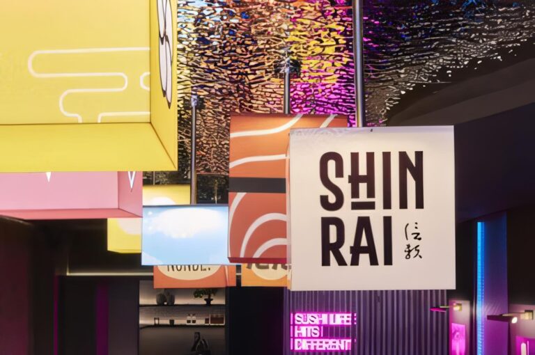 Modern Japanese restaurant interior featuring colorful hanging light boxes with the Shinrai logo and sushi motifs.