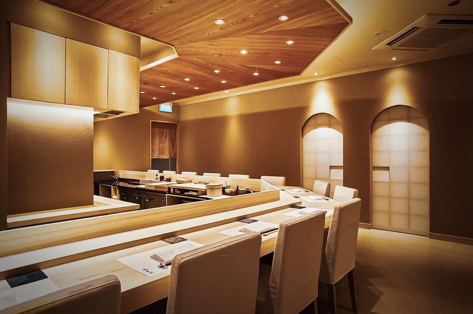 Japanese omakase sushi restaurant interior with wooden finishes, sushi bar seating, and traditional shoji screen design.