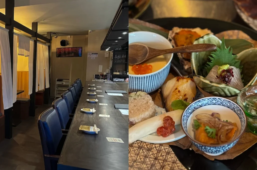 Showcases the intimate dining environment and an intricately prepared meal at a Japanese omakase restaurant. The left half of the image captures an empty, elegant dining room featuring a long, dark wooden counter lined with dark blue upholstered chairs. Each seating placement is meticulously set with a small plate, chopsticks, and a folded napkin, while private dining booths with white noren curtains line the opposite wall under warm, soft lighting. The right half of the image presents a vibrant, close-up view of an omakase platter served on a patterned mat. The meticulously arranged dishes include a blue-and-white patterned bowl filled with a savory mixture, a piece of perfectly seared fish, a small bowl of chawanmushi topped with bright orange ikura (salmon roe) and a wooden spoon, and a green, leaf-shaped dish holding fresh sashimi garnished with a shiso leaf and a touch of wasabi.