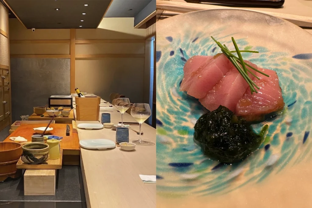 A split-screen image. The left side features an empty, upscale omakase dining room with light wood accents and a long counter set with wine glasses and blue ceramic cups. The right side shows a close-up of a beautiful ceramic plate with a swirling blue and white pattern, holding several thick slices of pink sashimi garnished with long, thin chives and a dark, glossy pile of marinated seaweed or kale.