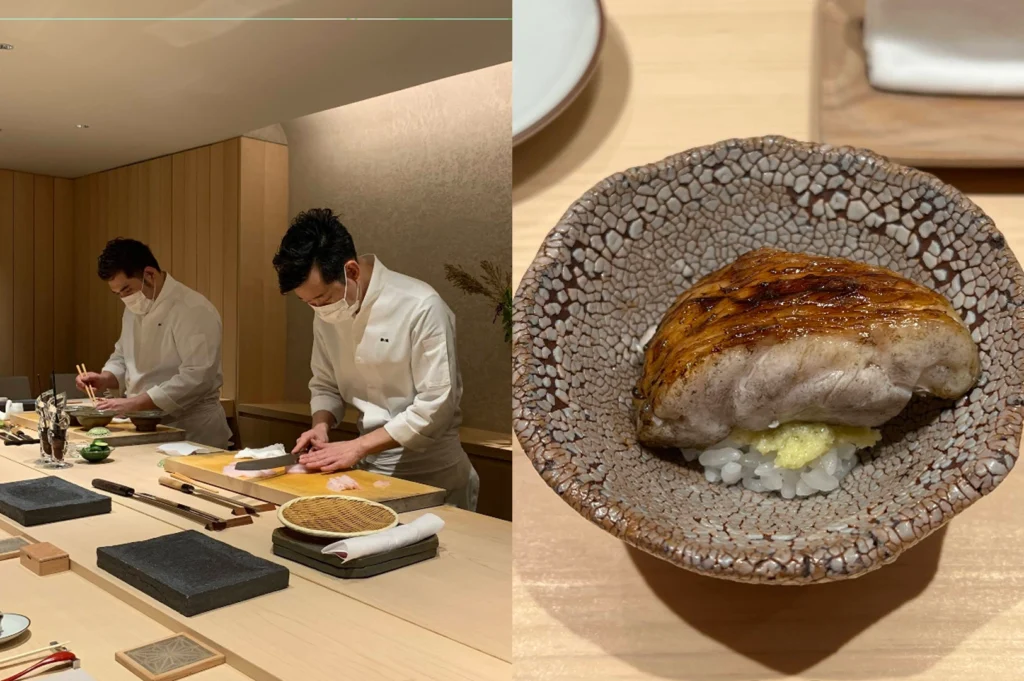A split-screen image. On the left, two chefs in white coats and face masks work behind a blonde wood counter, one carefully slicing fish with a long sushi knife. On the right, a macro shot shows a single piece of seared fish nigiri served in a unique, textured brown ceramic bowl that resembles cracked earth. The fish has a charred, golden-brown glaze and sits atop a small bed of white sushi rice with a touch of grated ginger.