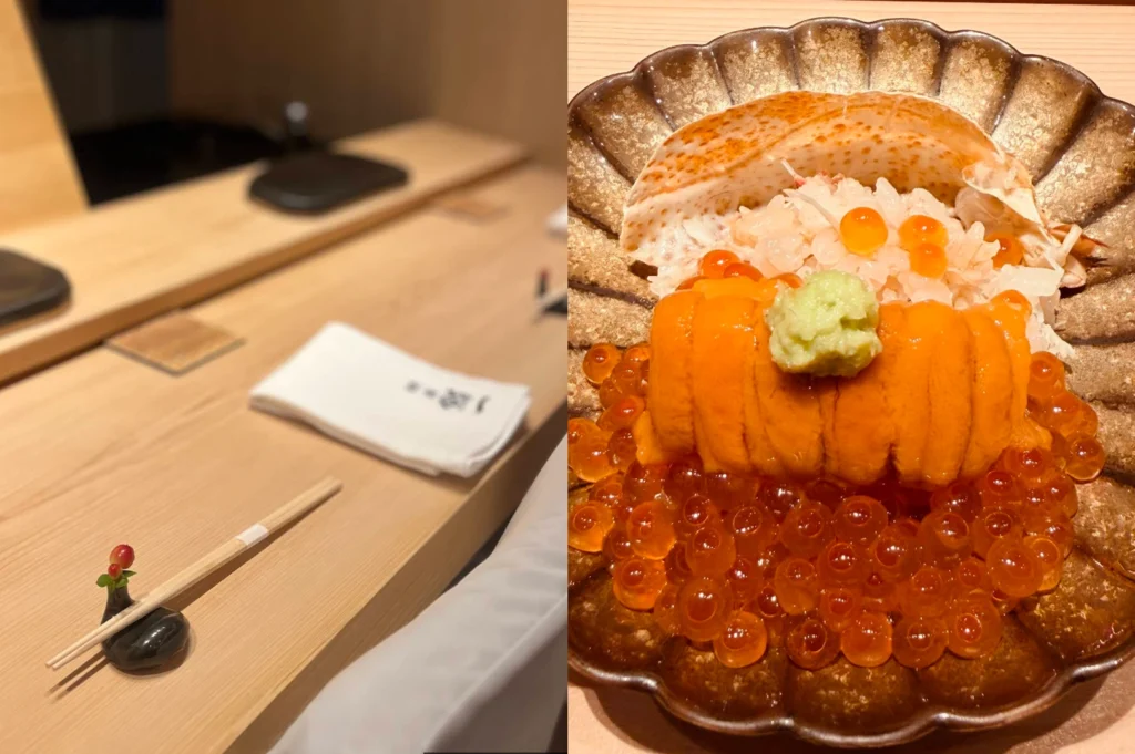 This split image shows a Japanese omakase dining experience. The left side captures a clean, minimalist wooden sushi counter featuring a folded white cloth napkin, a pair of wooden chopsticks resting on a small black holder adorned with a tiny green leaf and red berry, and empty seating areas blurred in the background. The right side is a close-up of a decadent, vibrant seafood dish served in a scalloped, metallic gold and brown bowl. It features a generous mound of bright orange sea urchin (uni) topped with a small dollop of green wasabi, sitting on a bed of shredded crab meat and rice, all surrounded by a large, glistening pile of translucent orange salmon roe (ikura) with a piece of crab shell visible in the background.