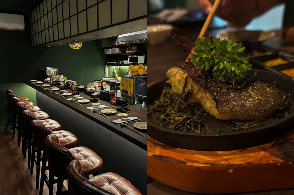 This split-screen image presents a moody, dimly lit restaurant interior paired with a richly textured cooked fish dish. The left half reveals a long, dark wood counter stretching into the background, lined with plush, tufted brown leather bar stools under a row of square grid-patterned panels, with a small yellow "OPEN" sign visible in the kitchen area. The right half features a close-up shot of a thick piece of grilled fish with a perfectly charred, shimmering skin served on a black cast-iron skillet, topped with a generous cluster of fresh green parsley and delicate red threads.