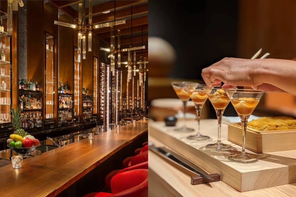 A two-panel image illustrating a high-end dining and cocktail experience. On the left, a sleek, polished wooden bar counter glows beneath warm, modern hanging cylindrical light fixtures, with plush red barstools lined up beside fully stocked liquor displays and a bowl of fresh fruit. On the right, a chef's hand uses delicate wooden chopsticks to place fresh sea urchin (uni) atop delicate glass cocktail coupe dishes containing layered savory delicacies set upon a light wood counter block.